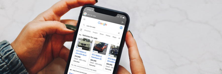 Image of person shopping for a used vehicle with Google Vehicle Ads on an iPhone